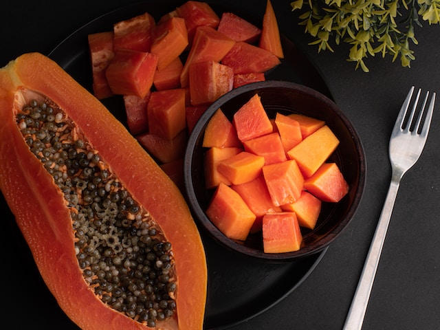 Pods of split papaya fruit displaying the seeds with coffee