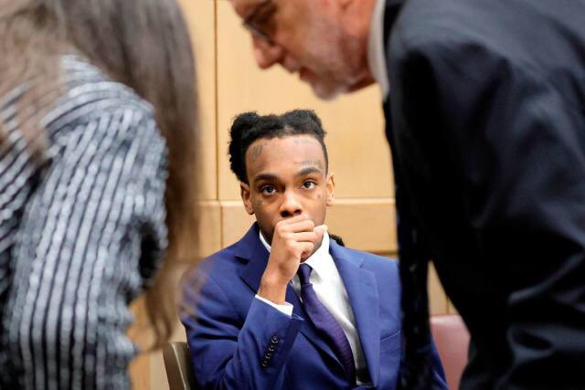 YNW Melly looks intently in court at his legal team deliberating